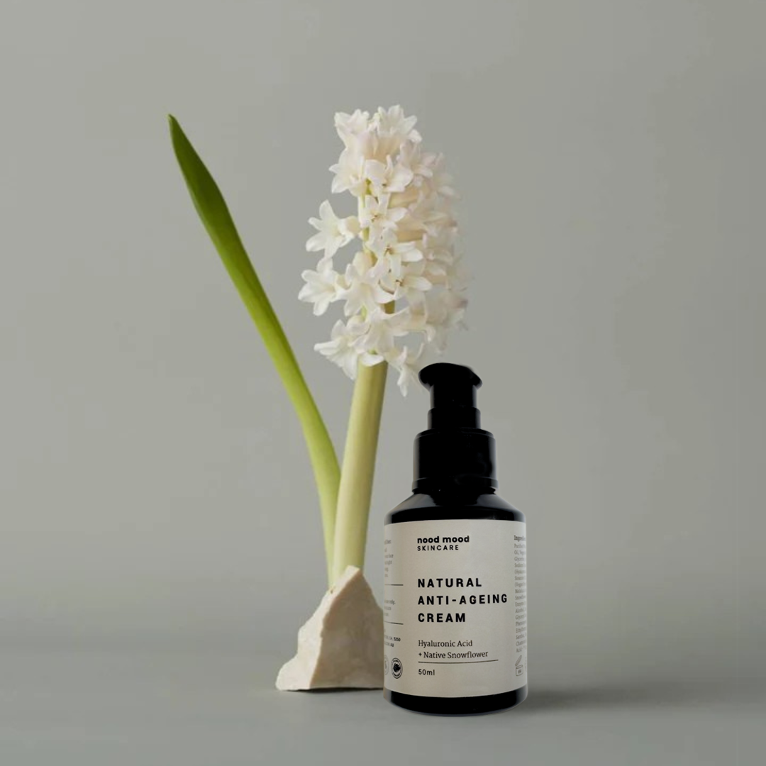 Nood Mood Skincare bottle labeled 'Natural Anti-Ageing Cream' next to a white flower on a gray background